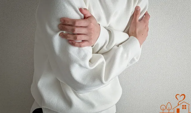 両腕を抱える人物