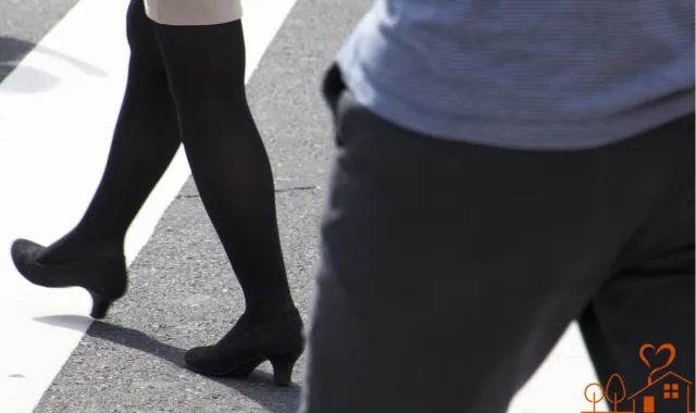 歩く女性の脚と、後ろを歩く男性