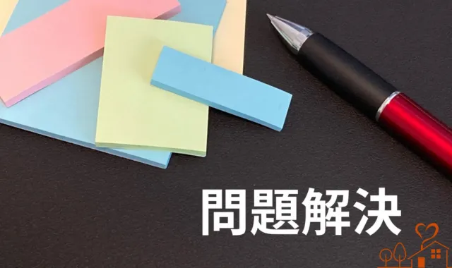 付箋とペンの下に問題解決の文字