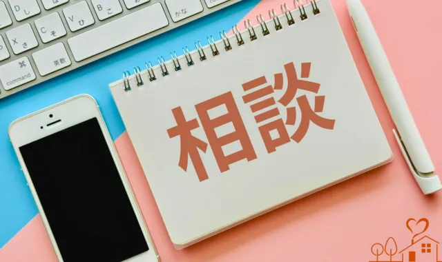 キーボードとスマホとペン、ノートに相談の文字