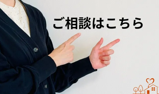 ご相談はこちらの文字を指さすスーツ女性