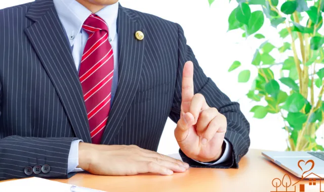 上を指さす弁護士