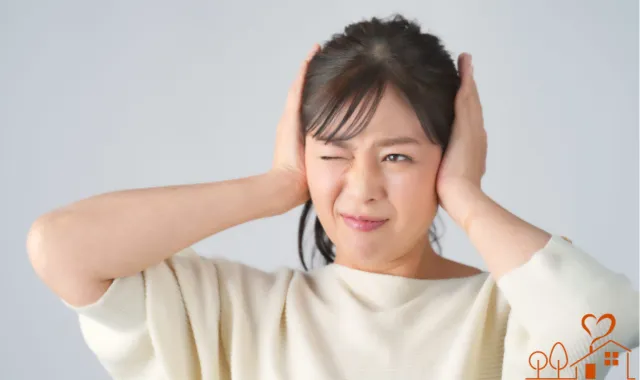 耳をふさぐ女性