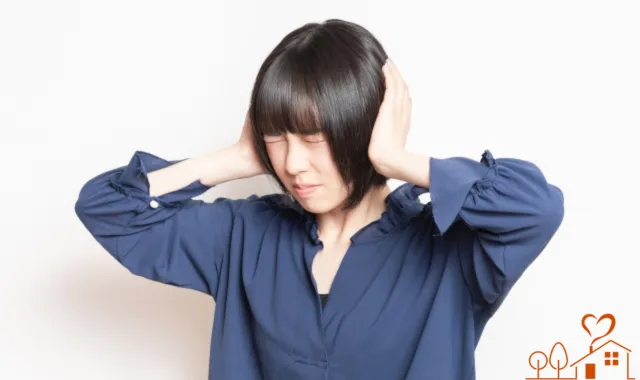 耳をふさぐ女性